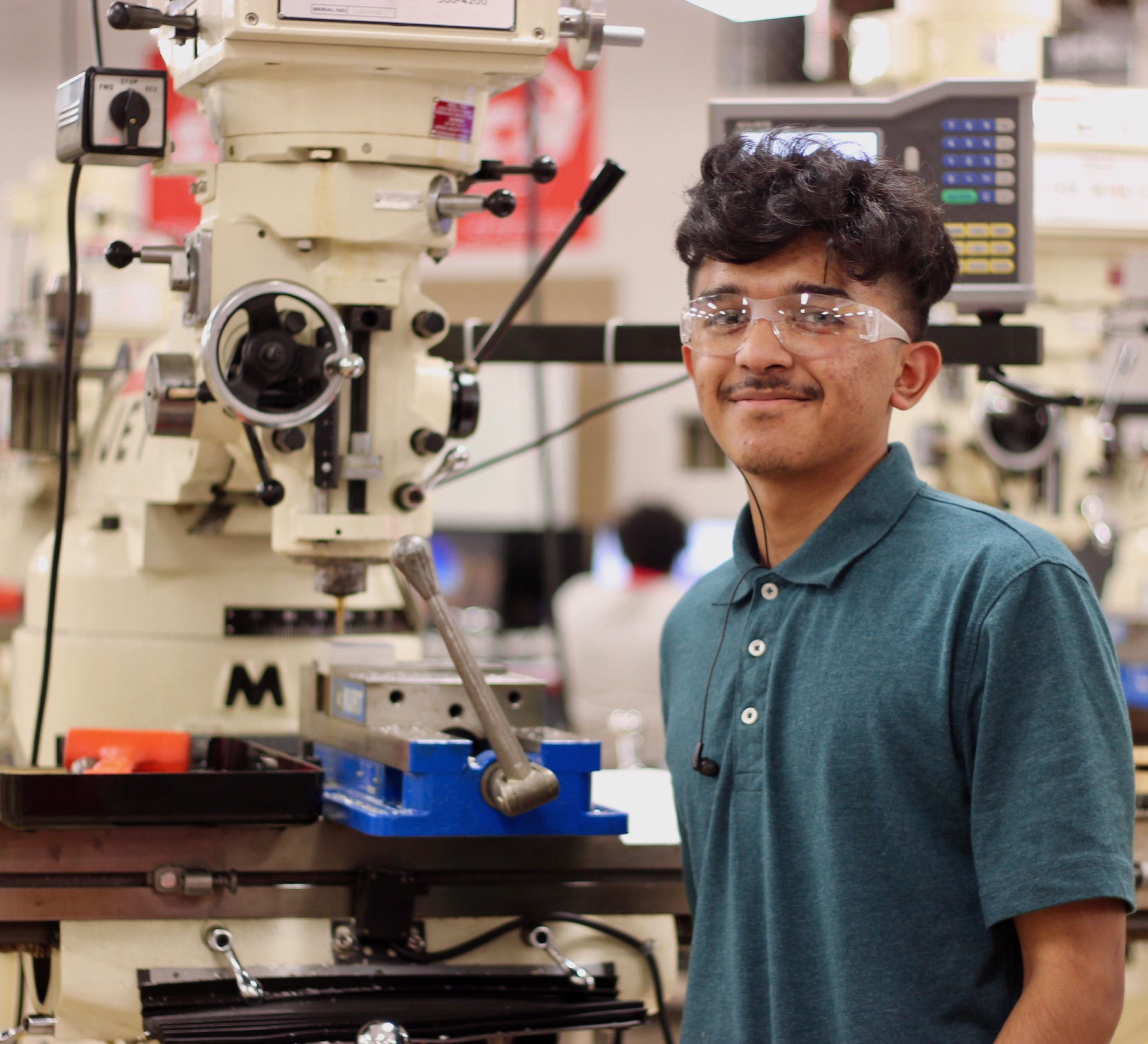 A student learning how to operate a machine